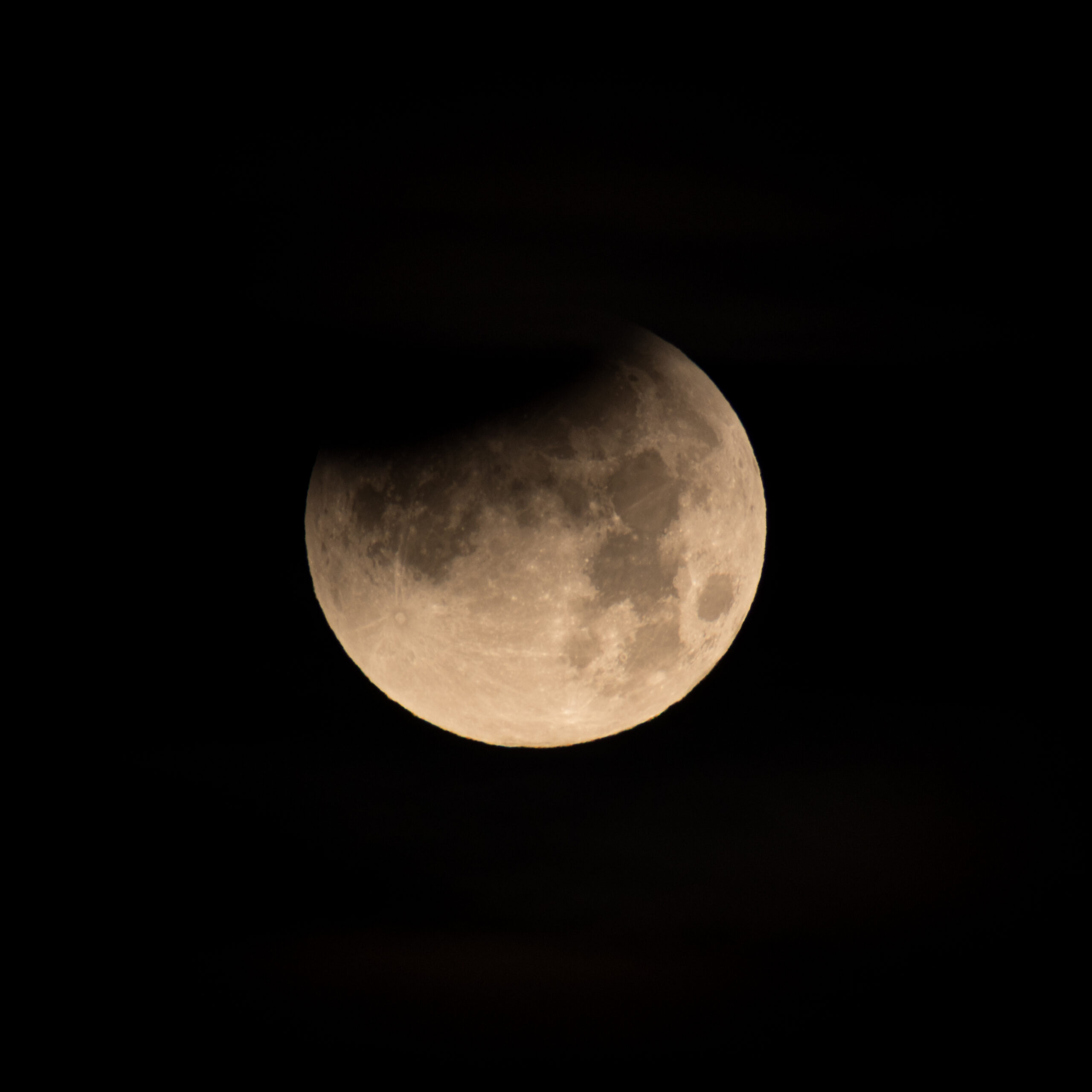 Earth's curved shadow moving across the Moon during a partial lunar eclipse