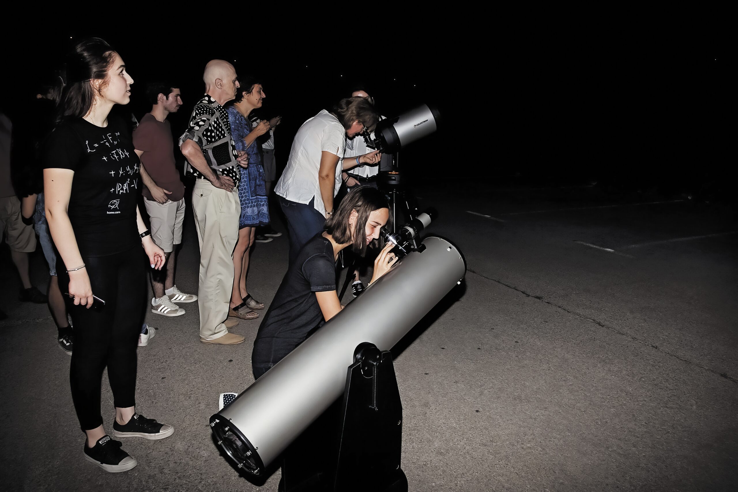 Astronomers gathered around telescopes during a night-time star party